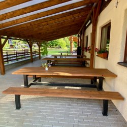 Záhradné stoly s lavičkami na terase reštaurácie